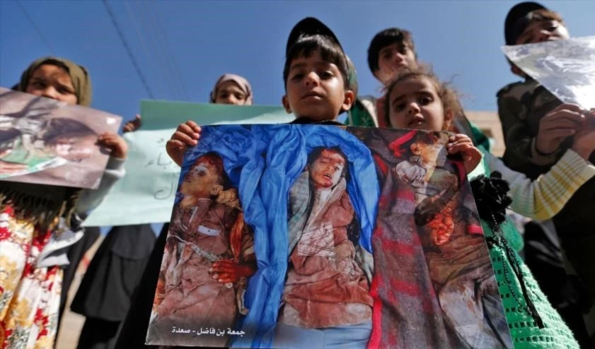 Niños yemeníes llevan fotos de varias víctimas durante la ceremonia de 1000 días de agresión saudí a Yemen, en Saná, 21 de diciembre de 2017. Foto: HispanTv