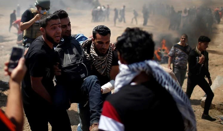 Palestinos socorren a uno de los compatriotas heridas durante la Marcha del Retorno. Palestinos socorren a uno de los compatriotas heridas durante la Marcha del Retorno.