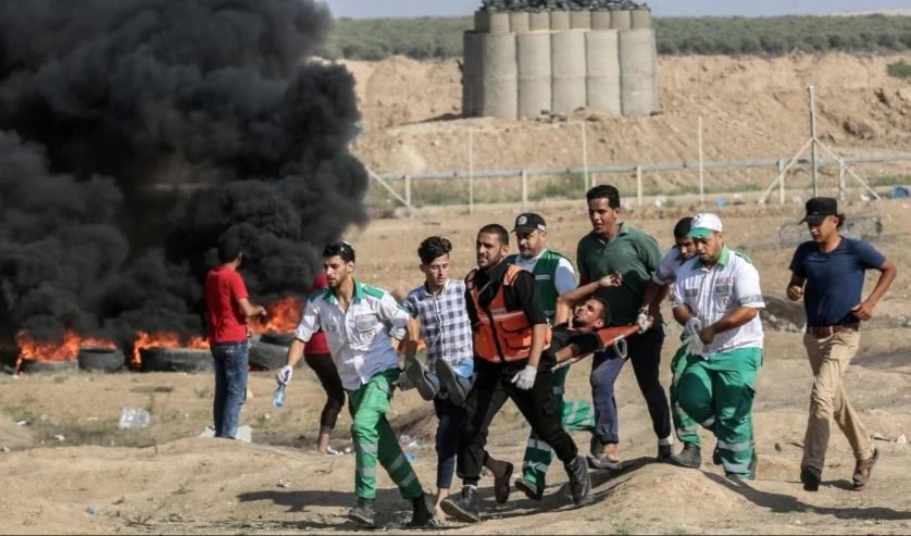 Personal médico traslada a palestino herido por las fuerzas de la ocupación en el este de la Franja de Gaza.