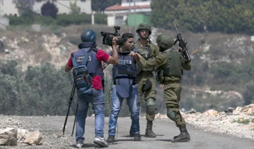 Soldados israelíes se enfrentan a un periodista palestino en la Cisjordania ocupada.