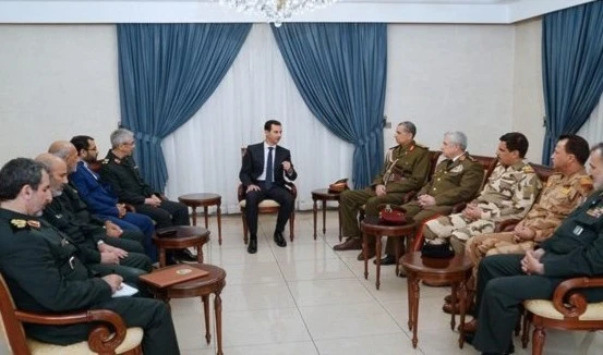 Bashar Al Assad dialoga con los generales Othman Al Ghanami y Mohammad Baqeri, jefes de los Estados mayores de Irak e Irán, respectivamente.
