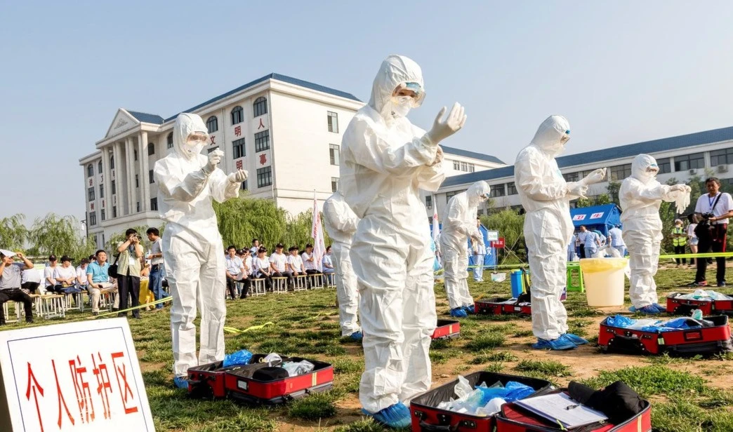 Un grupo de personas participan en un ejercicio de emergencia para la prevención y el control del virus de la gripe aviar H7N9 en Hebi (China). Foto: Reuters