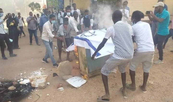 Jóvenes sudaneses queman bandera israelí.