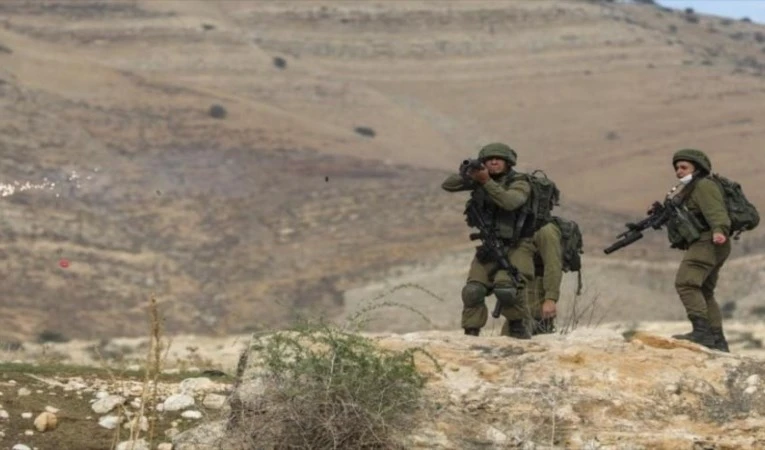 Soldados israelíes se esconden detrás de tela en frontera libanesa.