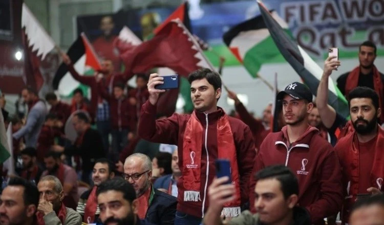 La bandera de Palestina ondea en manos de aficionados durante los encuentros de fútbol en la Copa Mundial de Qatar.