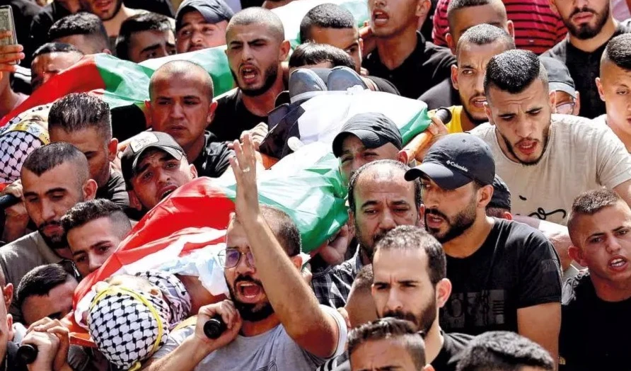 Palestinos alzan en sus hombros los cuerpos sin vida de las víctimas de la represión israelí.