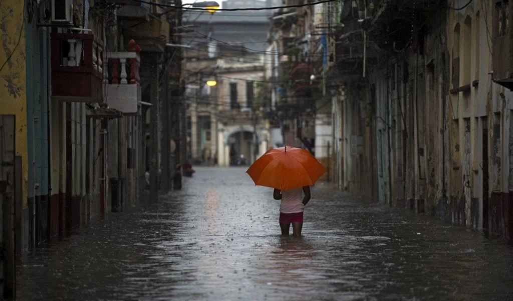 Un hombre con un paraguas en una calle inundada de La Habana