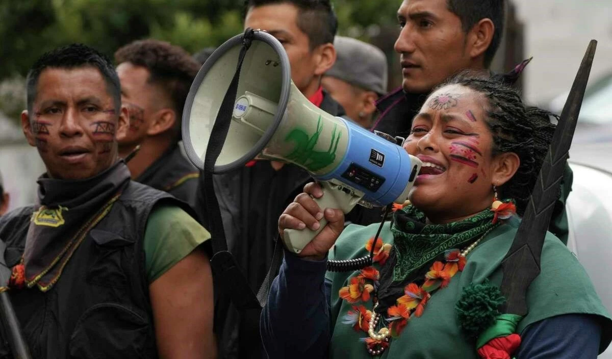 Mujer indígena A'i Cofán habla por un megáfono durante una manifestación frente a la Corte Constitucional. Foto: AP