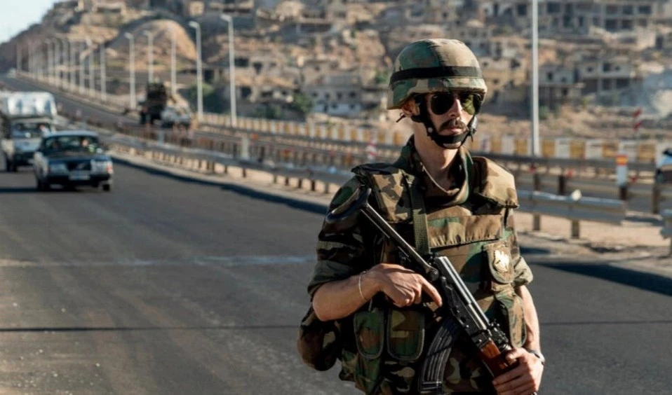 soldado sirio monta guardia en una carretera principal que conduce a la ciudad de Rastan, en la provincia central de Homs.