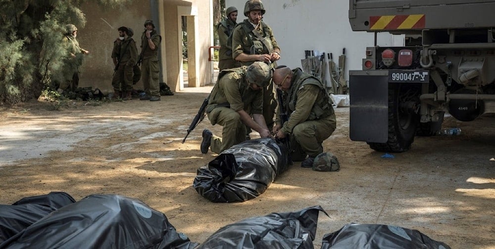 Soldados israelíes amarran envuelven los cuerpos de los fallecidos.