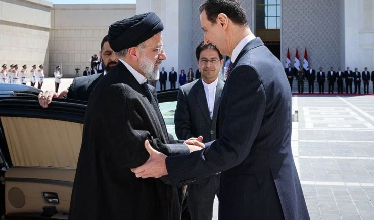 El presidente sirio, Bashar al-Assad, saluda a su homólogo iraní Ebrahim Raisi.