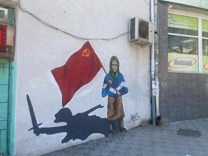  Mural de la anciana protegiendo la bandera roja en Donbas.