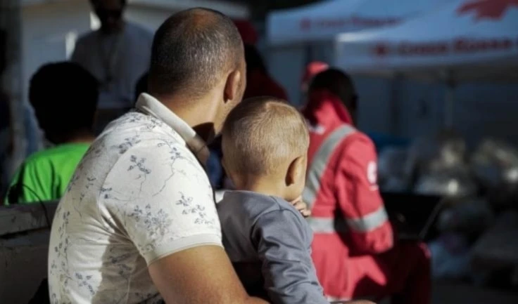 Migrantes de Túnez, cerca de las tiendas de campaña de la Cruz Roja italiana en el centro de recepción "punto caliente" en la isla de Lampedusa.