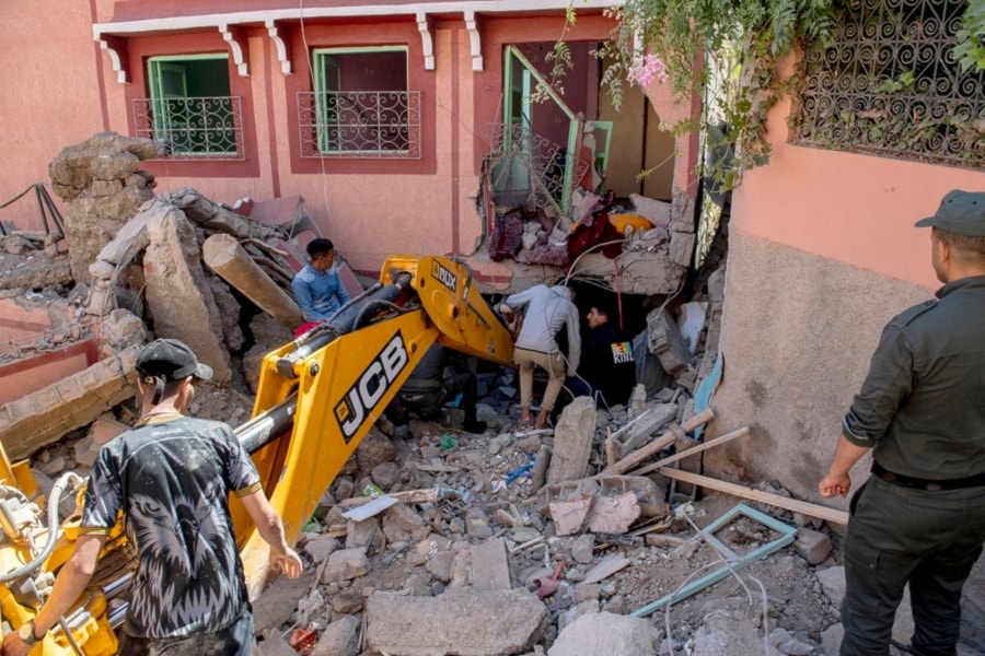 Varias personas tratan de retirar los escombros en un edificio dañado en la ciudad de Marrakesh. 