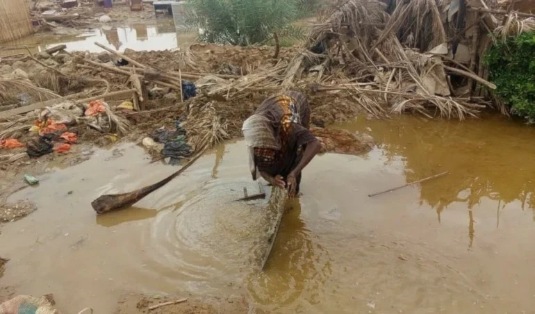 Una mujer busca en el agua cerca de su casa. Foto: AP.