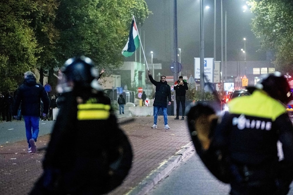 Un joven iza la bandera palestina en las calles de Ámsterdam (Foto: Agencias)