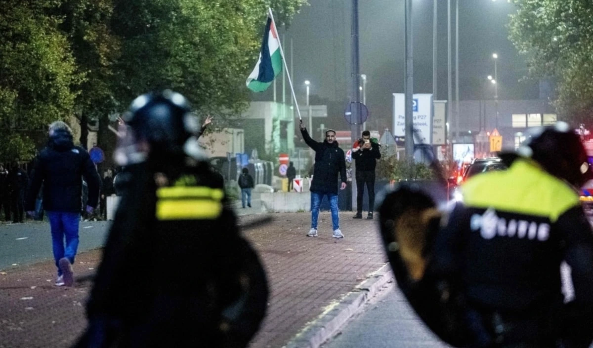 Un joven iza la bandera palestina en las calles de Ámsterdam (Foto: Agencias)