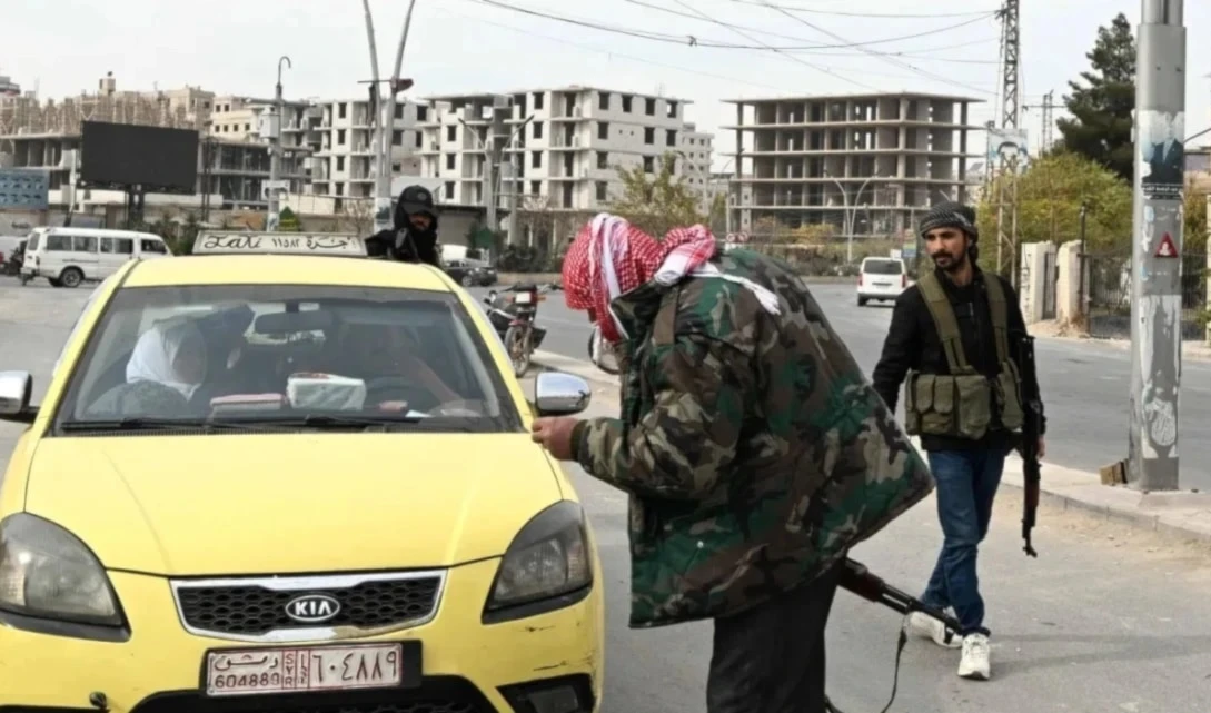 Miembros de grupos armados patrullan las calles de Damasco.