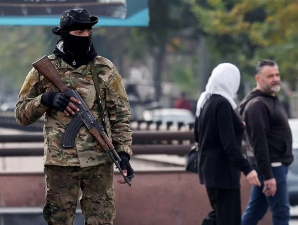 Miembro de gruo armado protege la plaza Abbasid en Damasco.