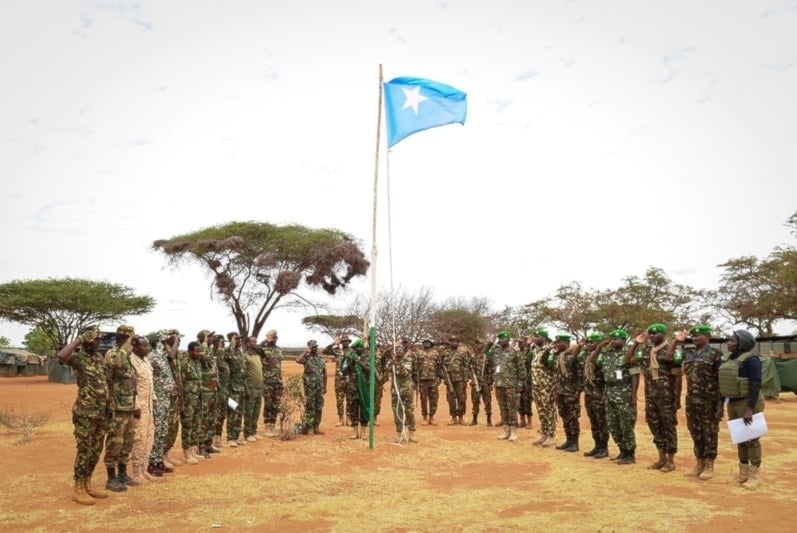 La Misión de Transición de la Unión Africana en Somalia y oficiales del Ejército Nacional Somalí saludan la bandera somalí.