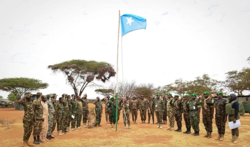La Misión de Transición de la Unión Africana en Somalia y oficiales del Ejército Nacional Somalí saludan la bandera somalí.