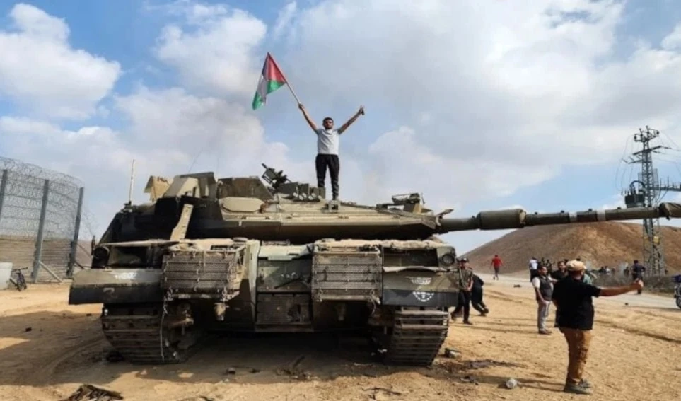 Un palestino sube a un tanque israelí tras el ataque de Hamas el 7 de octubre.