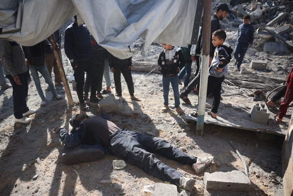 Palestinos reunidos en torno a un herido como resultado de un ataque al campamento de refugiados de Bureij.