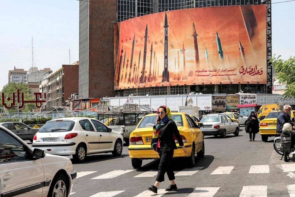 Un cartel enorme cartel en una avenida de Teherán muestra misiles balísticos iraníes con las palabras “Su Promesa es Veraz” e “´Israel´ es más débil que una tela de araña”.