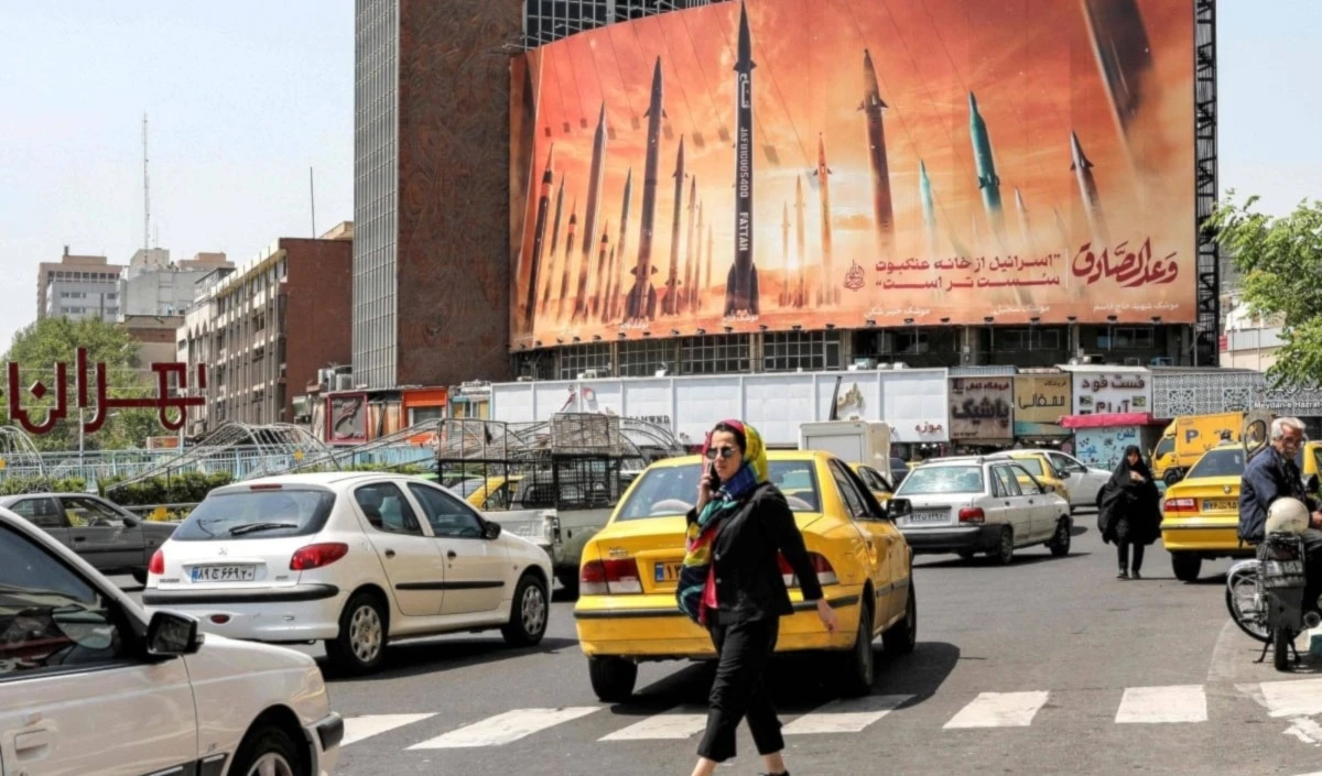 Un cartel enorme cartel en una avenida de Teherán muestra misiles balísticos iraníes con las palabras “Su Promesa es Veraz” e “´Israel´ es más débil que una tela de araña”.