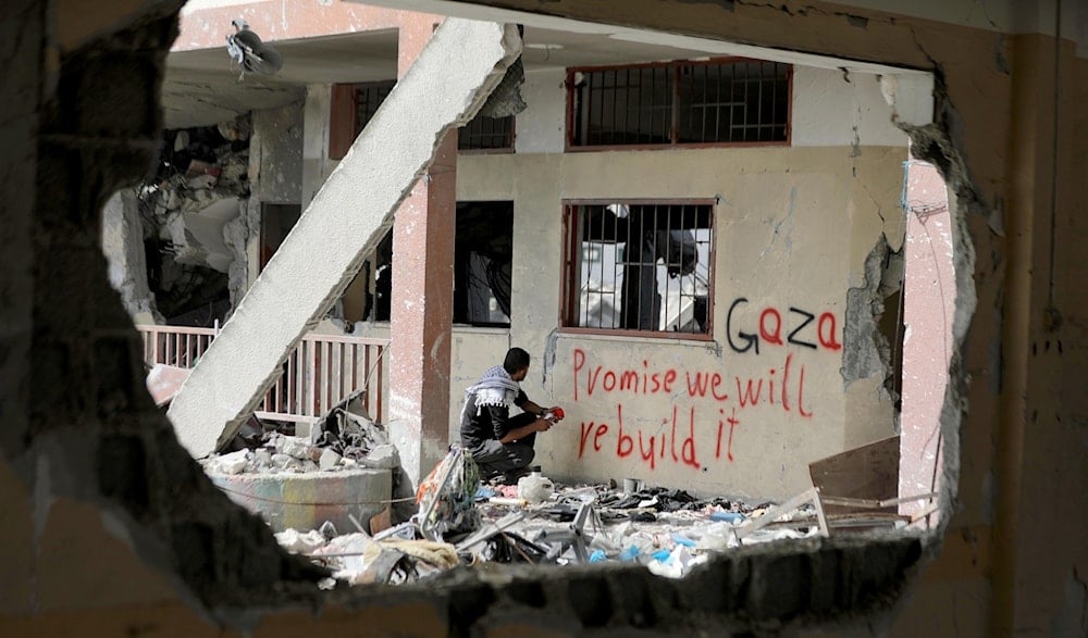 Joven palestino escribe en uno de los edificios bombardeado por la ocupación en Gaza