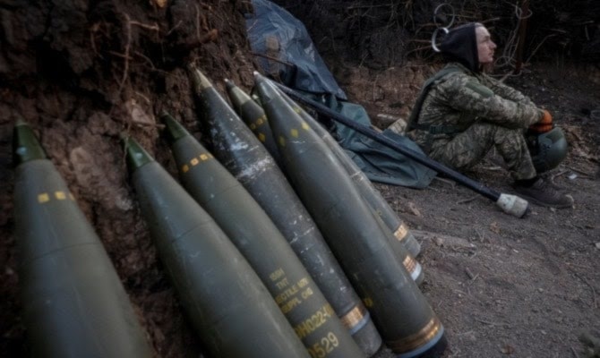 Soldado ucraniano sentado junto a proyectiles provenientes de ayuda militar occidental (Reauters)