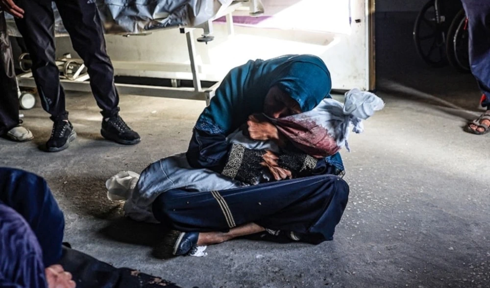 Mujer palestina abraza cuerpo de su hijo martirizado en bombardeo israelí a Rafah. 26 de mayo 2024