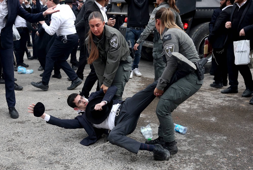 Un ultraortodoxo israelí arrestado por manifestarse contra el reclutamiento en el servicio militar.