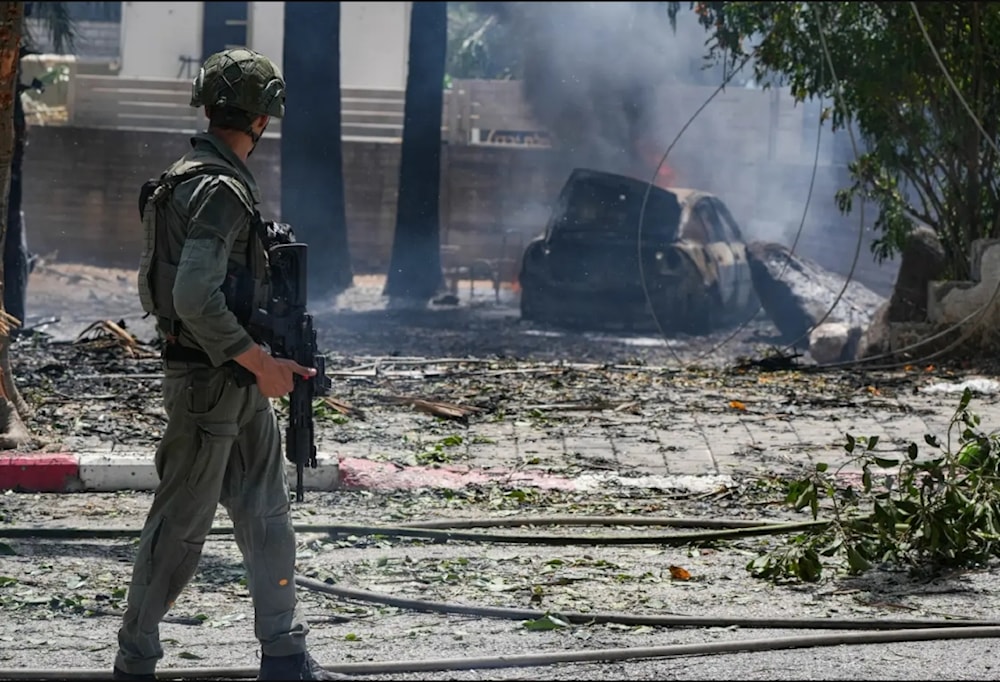 Soldado israelí en el lugar de impacto de un cohete de la resistencia en el asentamiento de Kiryat Shmona  