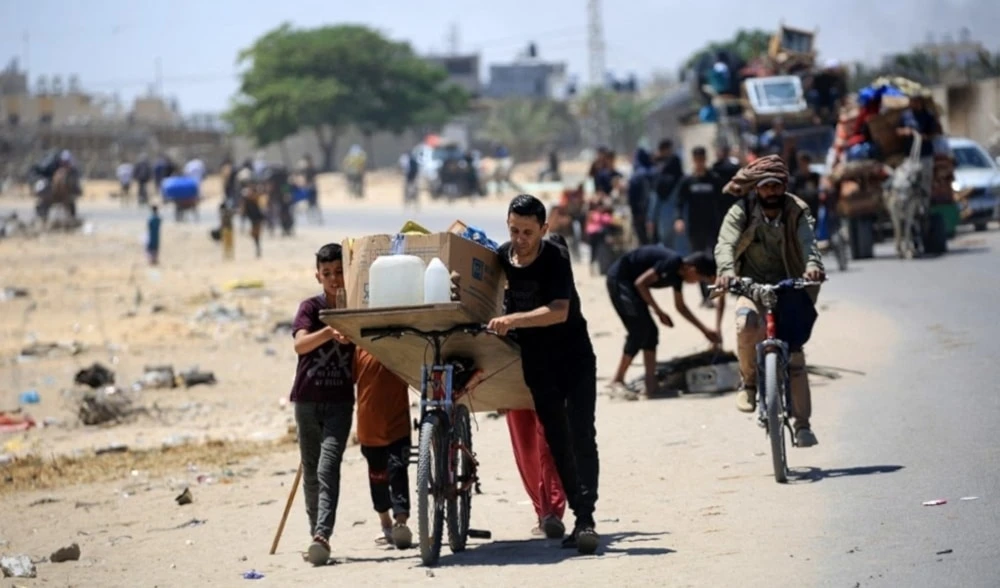 Palestinos transportan sus pertenencias durante su desplazamiento de la zona de Tal al-Sultan en Rafah. Foto: AFP.