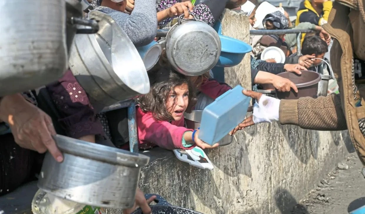 Palestinos hacen cola para obtener una ración de comida en Rafah, en el sur de la Franja de Gaza.