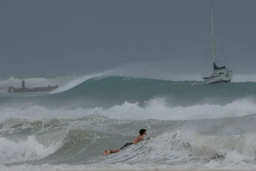 Surfista desafía las olas durante el paso del huracán Beryl por Barbados. Foto: AP.