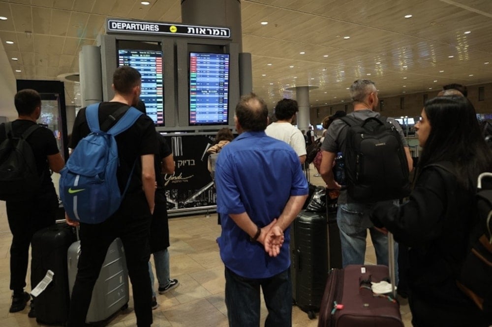 Los pasajeros miran el panel de salidas en el aeropuerto Ben Gurion de 