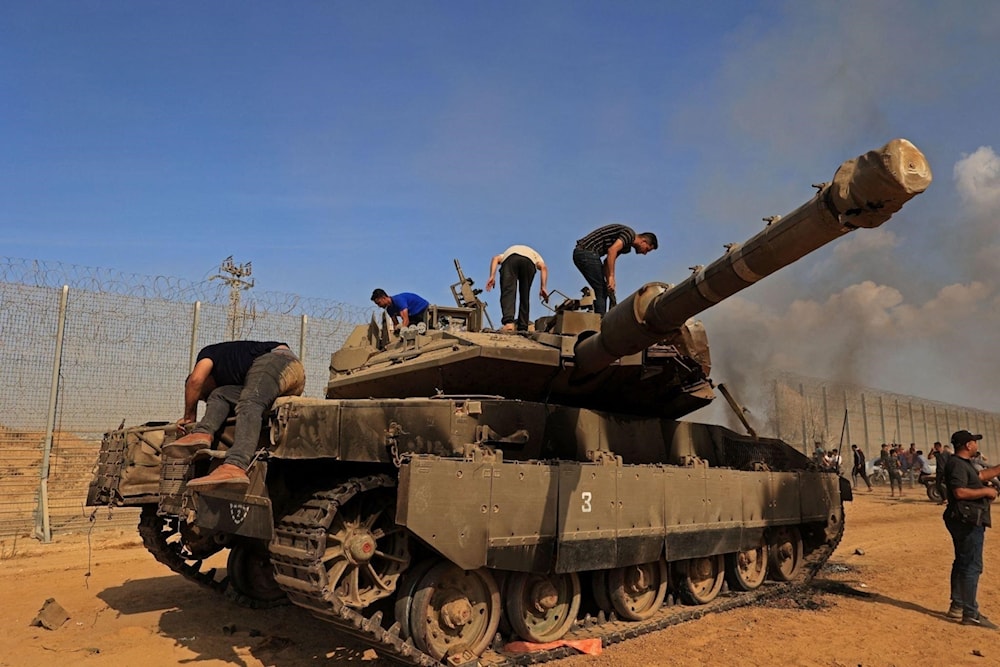 Gazatíes sobre un tanque israelí tras entrar a las tierras palestinas ocupadas el 7 de octubre 2023.