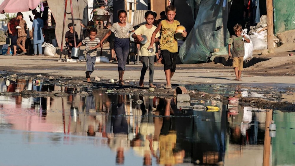 Niños en comunidades desplazadas en la Franja de Gaza cerca de aguas contaminadas como consecuencia de la agresión israelí. Foto: AFP