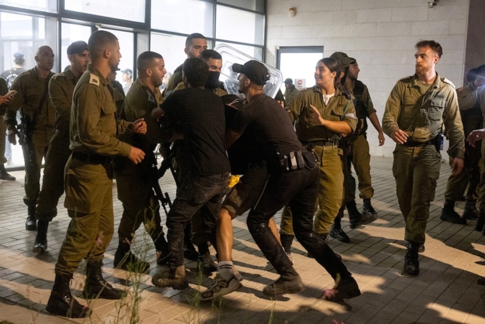 Militares israelíes chocan con derechistas después de irrumpir en la base de Beit Lid, el 29 de julio 2024. Foto: AFP.