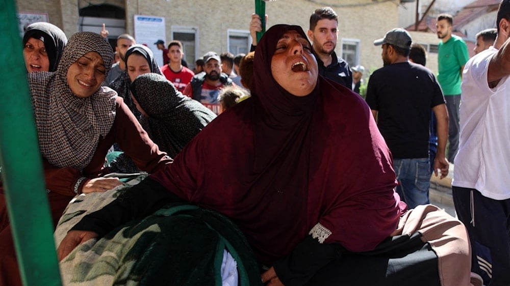 Palestinos se despiden de sus familiares muertos en un ataque israelí el jueves a dos escuelas de Gaza que albergaban a desplazados.