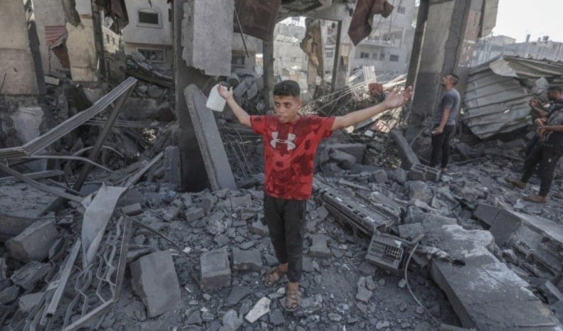 Niño palestino en medio de la destrucción masiva causada por los bombardeos israelíes al campamento de Bureij. (Foto: Red Informativa Al Quds)