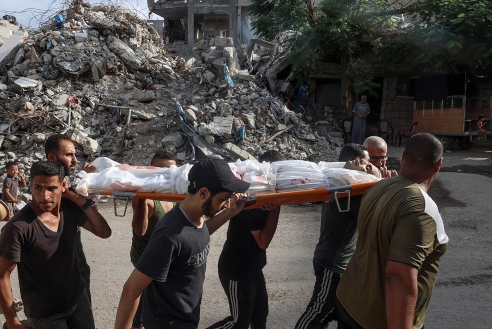 Palestinos trasladan a las víctimas de la masacre israelí contra el campamento de Al-Bureij. (Foto: AFP) 