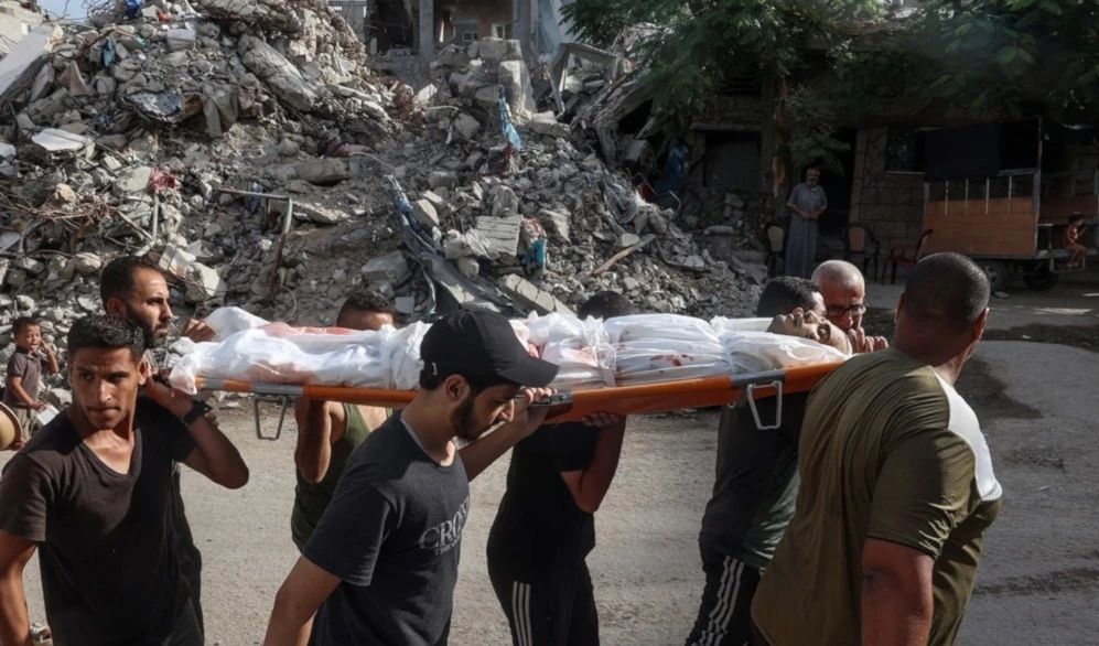 Palestinos trasladan a las víctimas de la masacre israelí contra el campamento de Al-Bureij. (Foto: AFP)