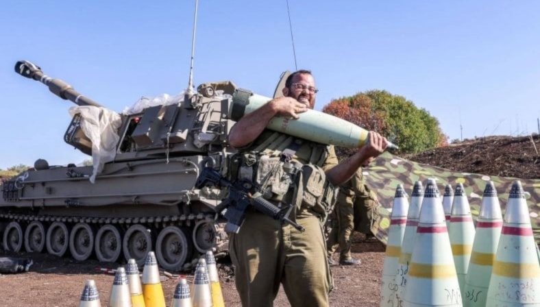 Soldado israelí porta un proyectil de artillería cerca de la frontera entre Palestina ocupada y Líbano (Foto: AFP)