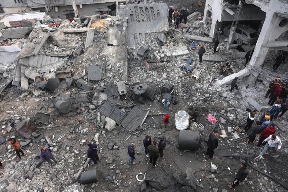 Palestinos inspeccionan escombros bajo los edificios en Jabalia provocados por bombardeos israelíes.