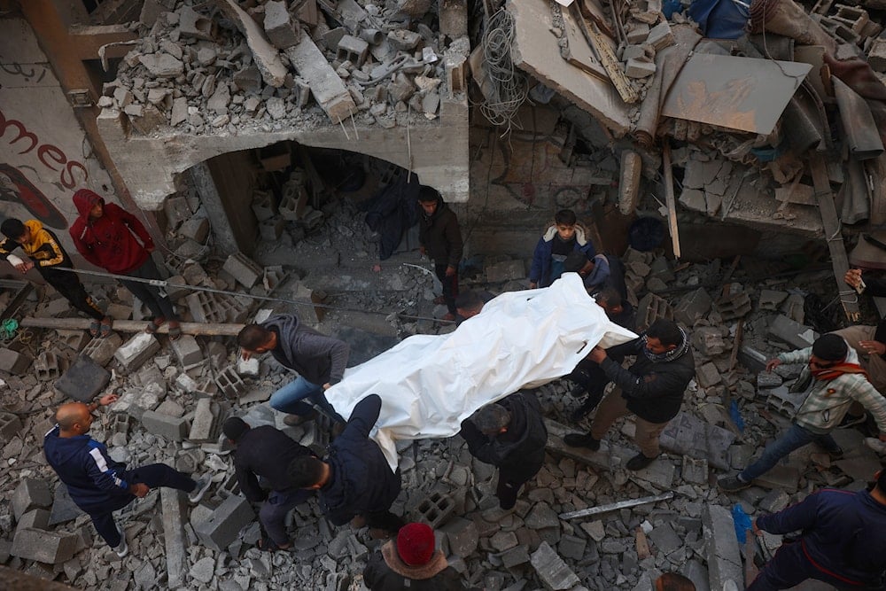 Palestinos recuperan el cuerpo de un mártir tras el bombardeo israelí al centro de Gaza. Foto: AFP