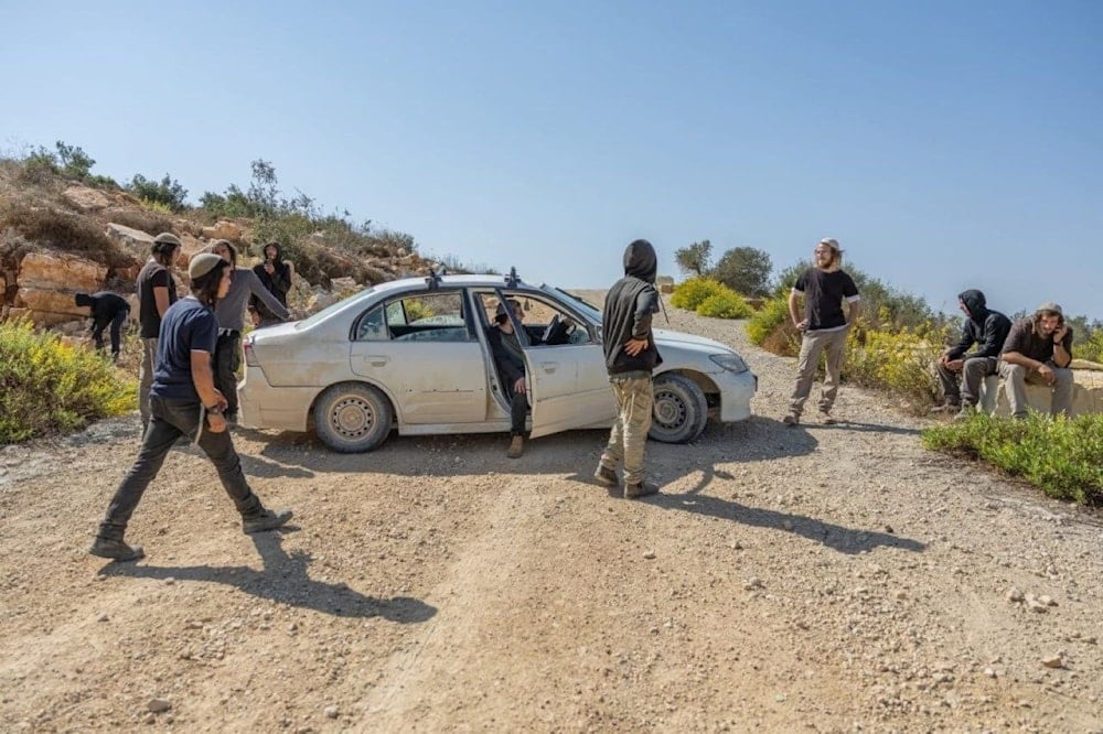 Colonos israelíes, bajo protección de las fuerzas de ocupación, impiden a agricultores palestinos transitar por sus tierras cultivadas de olivo en la ciudad de Silwa, en Ramala.  