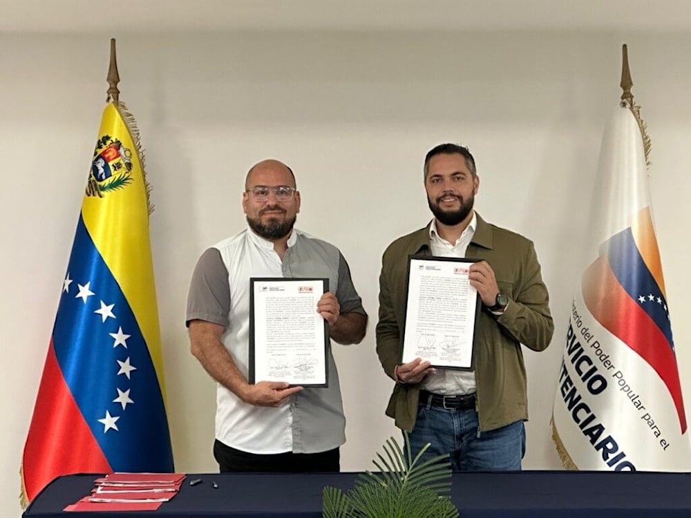 De izquierda a derecha, Omar Rangel, presidente de la Fundación Librerías del Sur, y Julio García Zerpa, ministro para el Servicio Penitenciario, firmando un acuerdo de bibliotecas en centros penitenciarios. 
